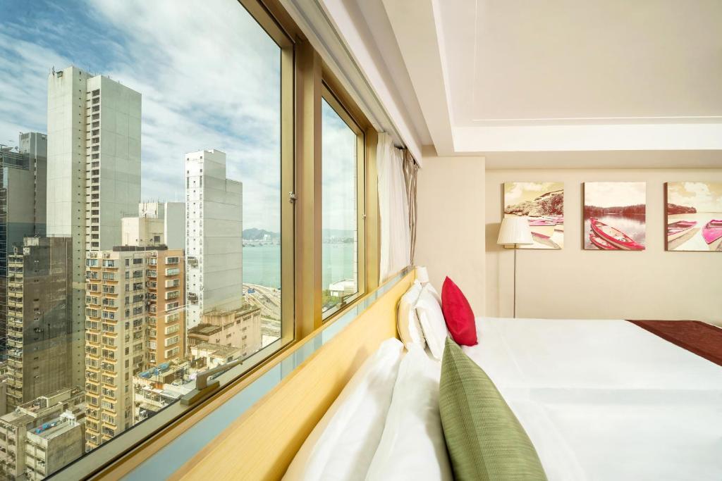 a bedroom with a bed and a large window at Eco Tree Hotel in Hong Kong