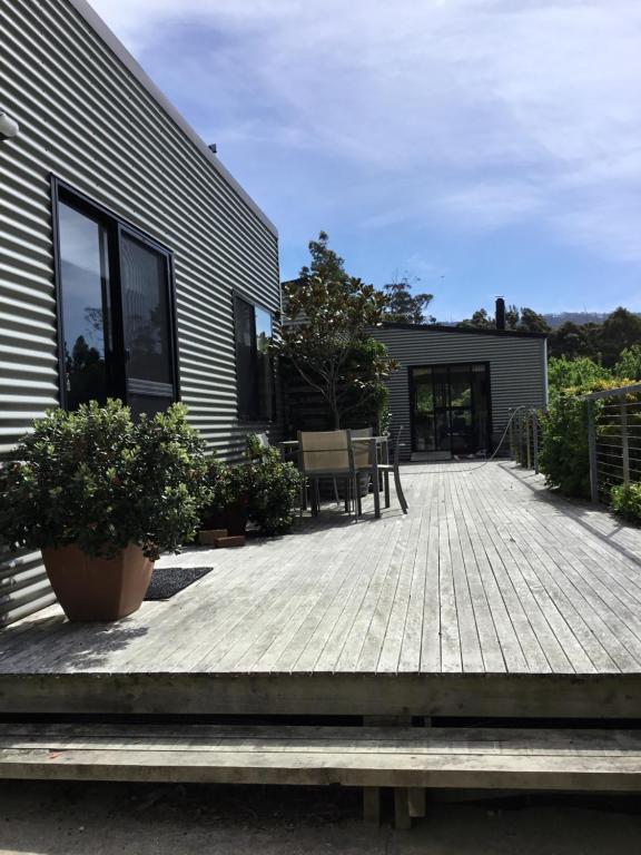 a patio with a wooden deck next to a building at Nextdoor@portarthur in Port Arthur