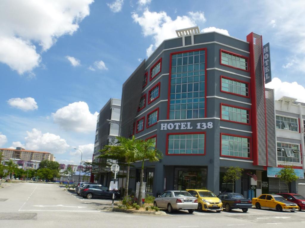 a tall building with cars parked in a parking lot at Hotel 138 @ Bestari in Shah Alam