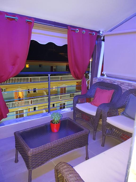 a balcony with chairs and a table and a window at Apartmani Vesna Paralia in Paralia Katerinis