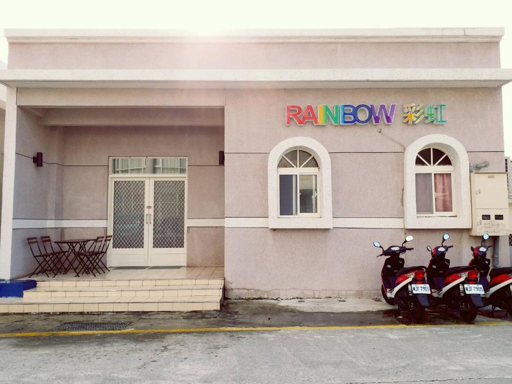 duas motos estacionadas em frente a um edifício em Rainbow Homestay em Ilha Verde