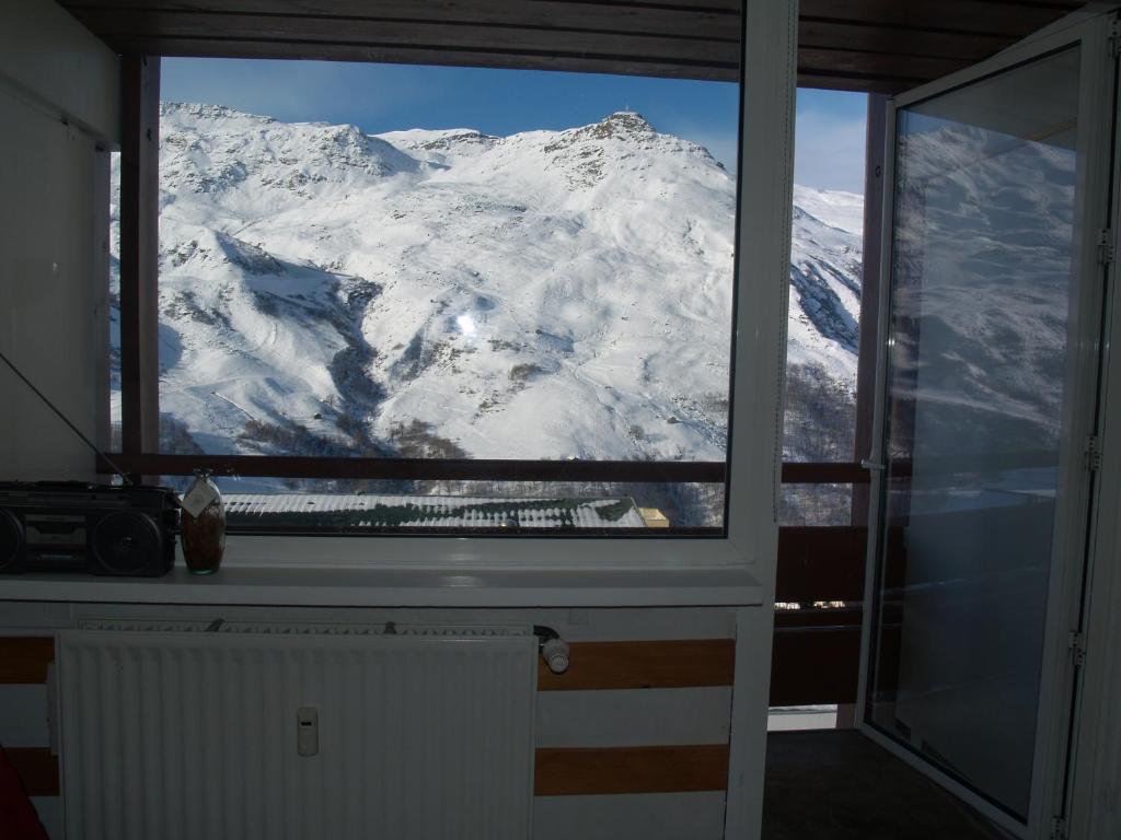 レ・メニュアールにあるles Lauzesの窓から雪山の景色を望む