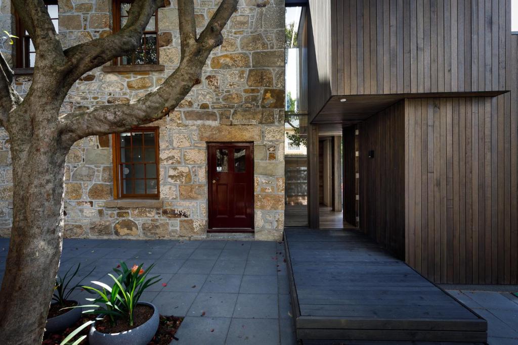 a walkway leading to a stone building with a door at Blue Magnolia in Hobart