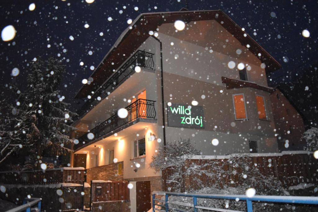un edificio con un cartel en la nieve en Willa Zdrój en Krynica Zdrój