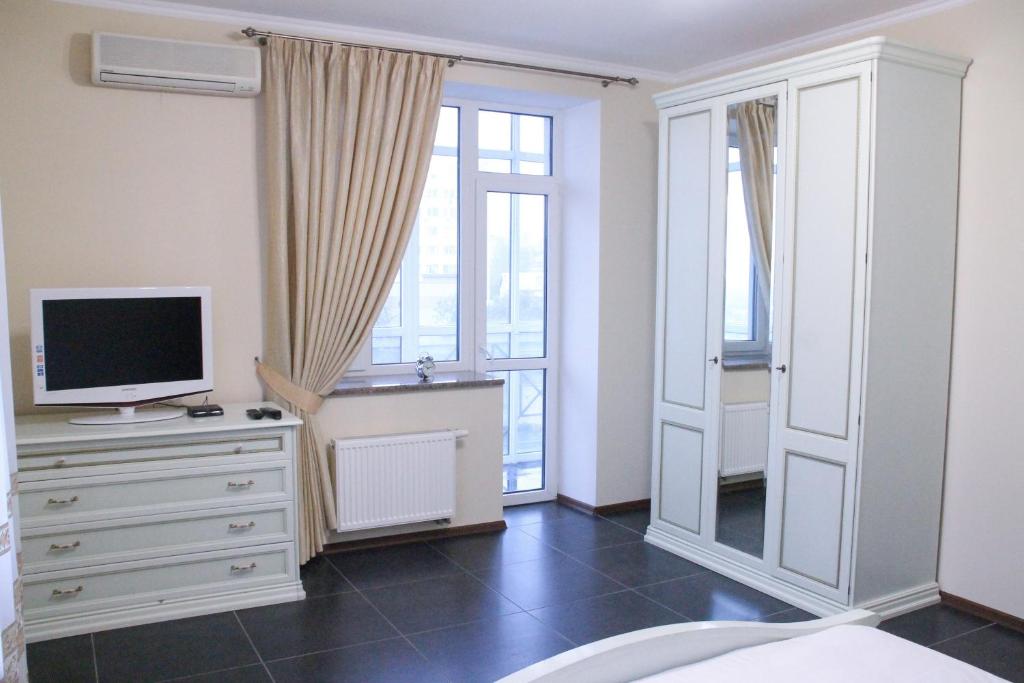 a bedroom with a television and a dresser with a tv at Apartment on Lukyanovska in Kyiv