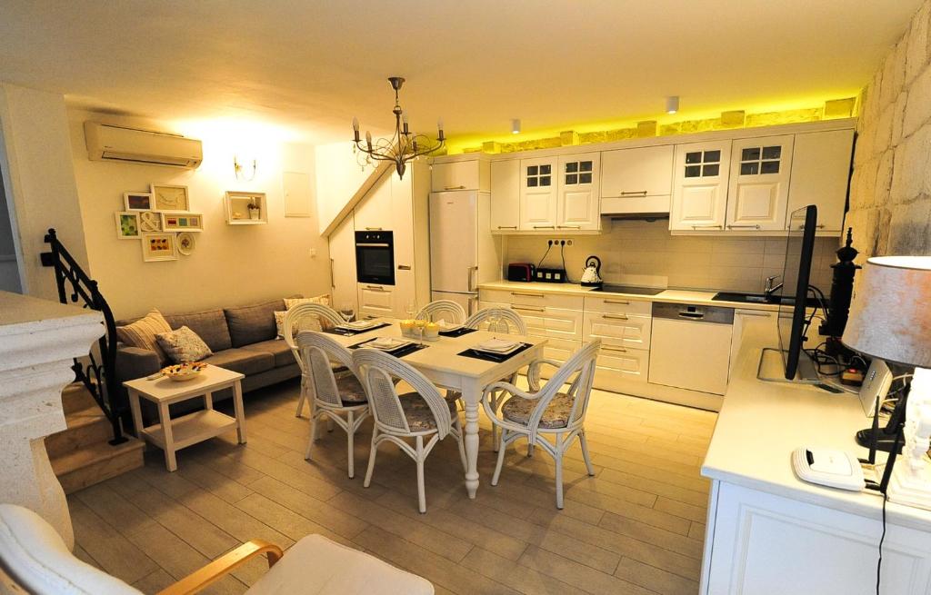 een keuken en een woonkamer met een tafel en stoelen bij House Vilović Korčula in Korčula
