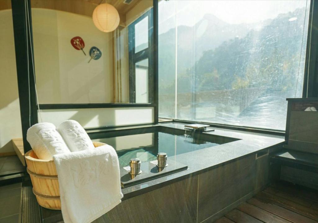 a bathroom with a sink and a tub with towels at Tangyue Resort in Tai&#39;an