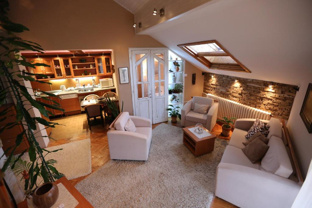 een woonkamer met witte meubels en een keuken bij Magic Apartment in Novi Sad