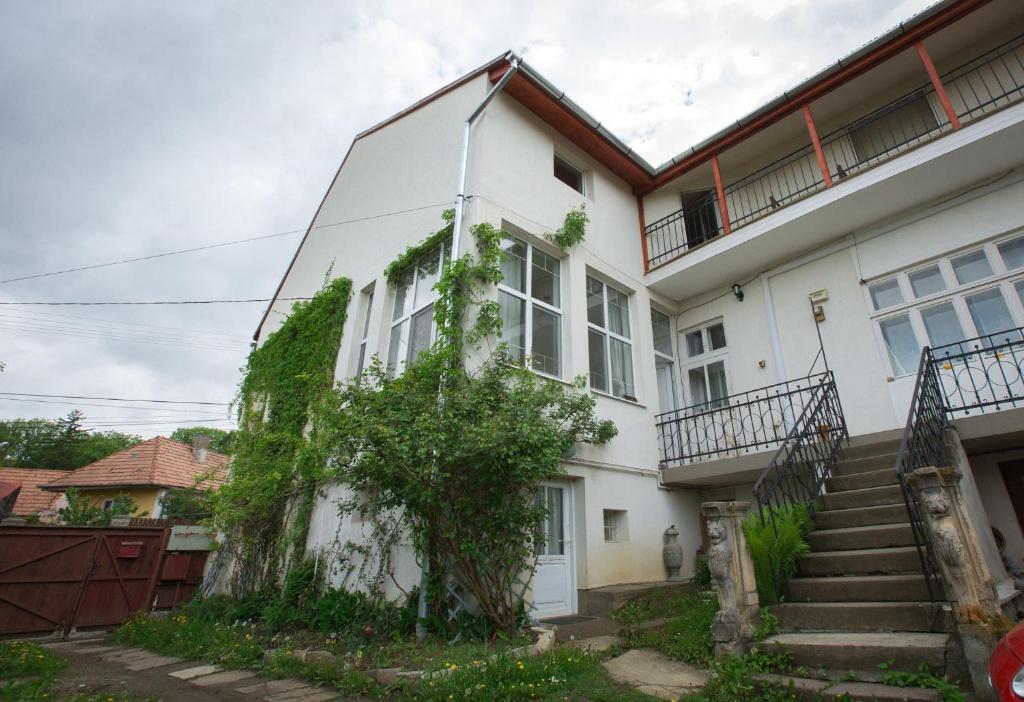 Una casa blanca con un árbol a un lado. en Casa Júlia, en Odorheiu Secuiesc