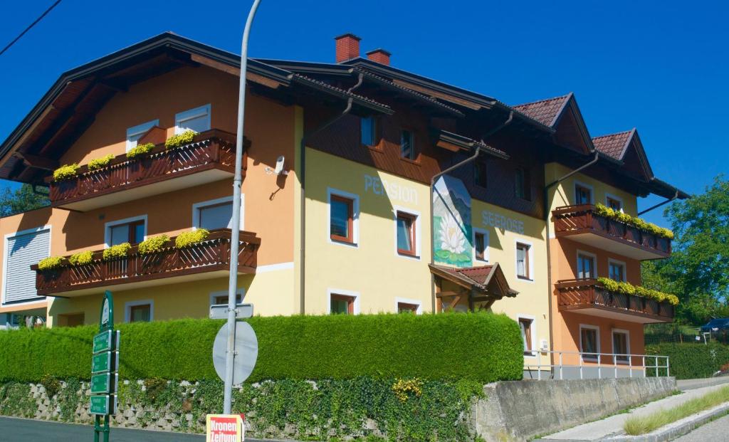 un edificio con flores en los balcones. en Pension Seerose, en Drobollach am Faakersee