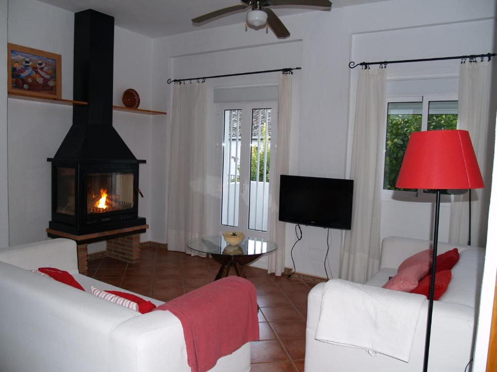 uma sala de estar com dois sofás brancos e uma lareira em Casa de Abajo em Prado del Rey