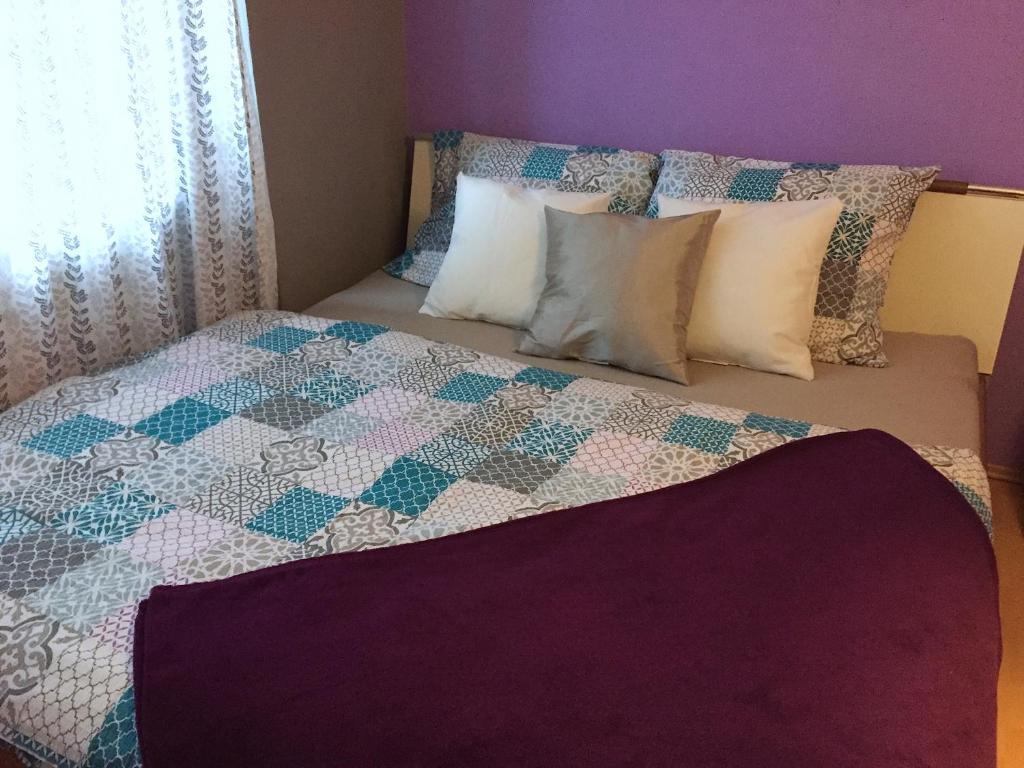 a bed with a quilt and pillows on it at Apartment Sophie Olomouc in Olomouc