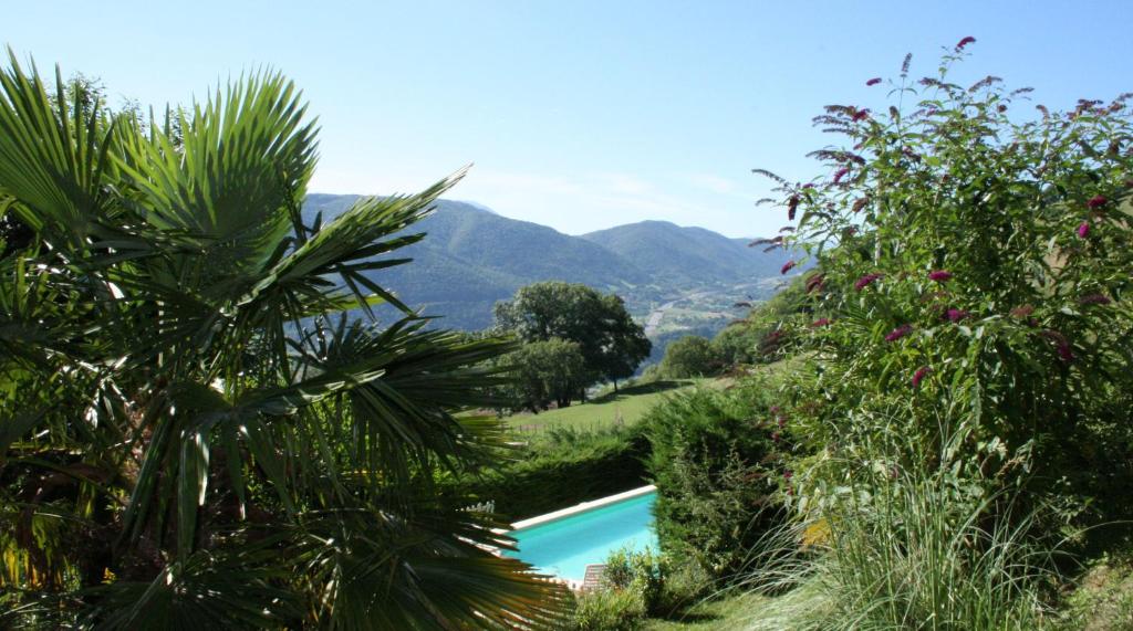 a swimming pool with mountains in the background at Domaine du Rocher St-Loup in Vif