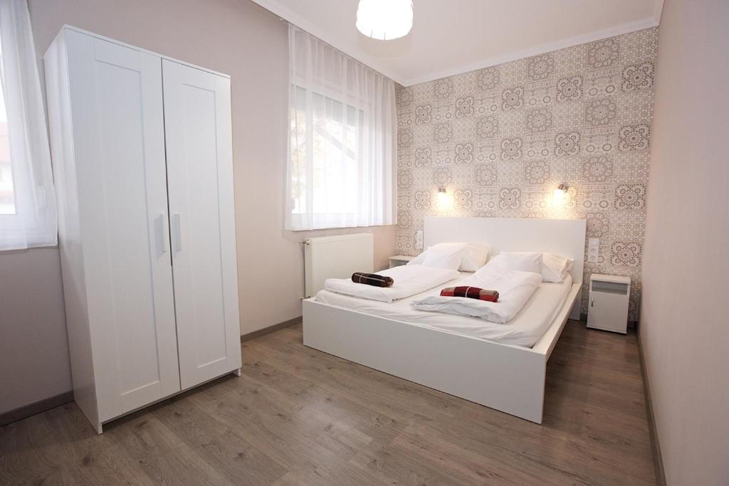 ハイドゥソボスローにあるZoli Apartmanok-Timi Kölcsey 34-36の白いベッドルーム(白いベッド1台、窓付)