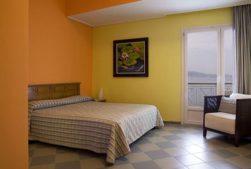 a bedroom with a bed and a window and a chair at Akti in Nafpaktos