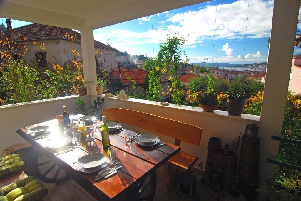 a table on a balcony with a view of the city at Apartment Salov in Trogir