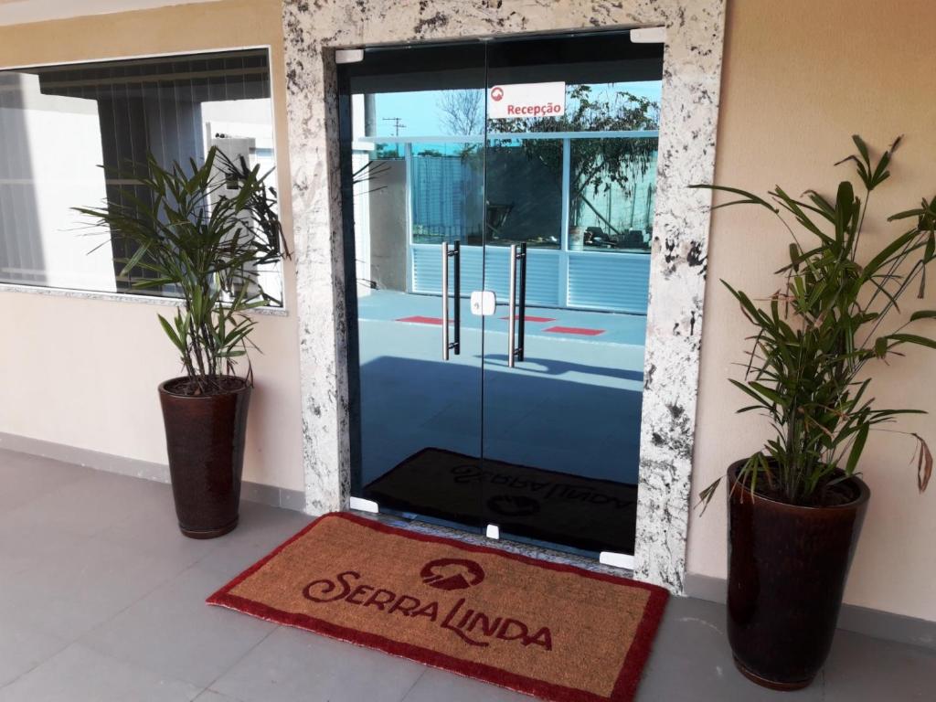 une porte dans un bâtiment avec deux plantes en pot dans l'établissement Serra Linda Hotel, à Serra