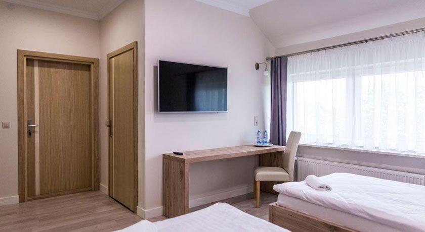 a bedroom with a bed and a desk and a television at Oleńka in Kutno