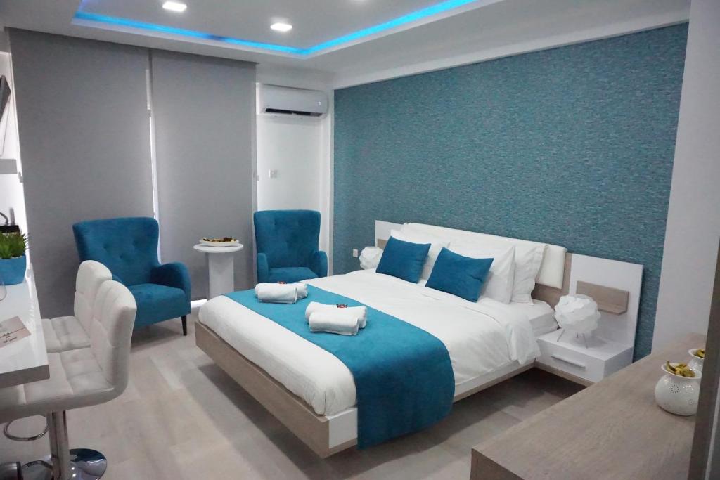 - une chambre avec un lit et deux chaises bleues dans l'établissement Lazuli Beach Apartment 209, à Larnaka