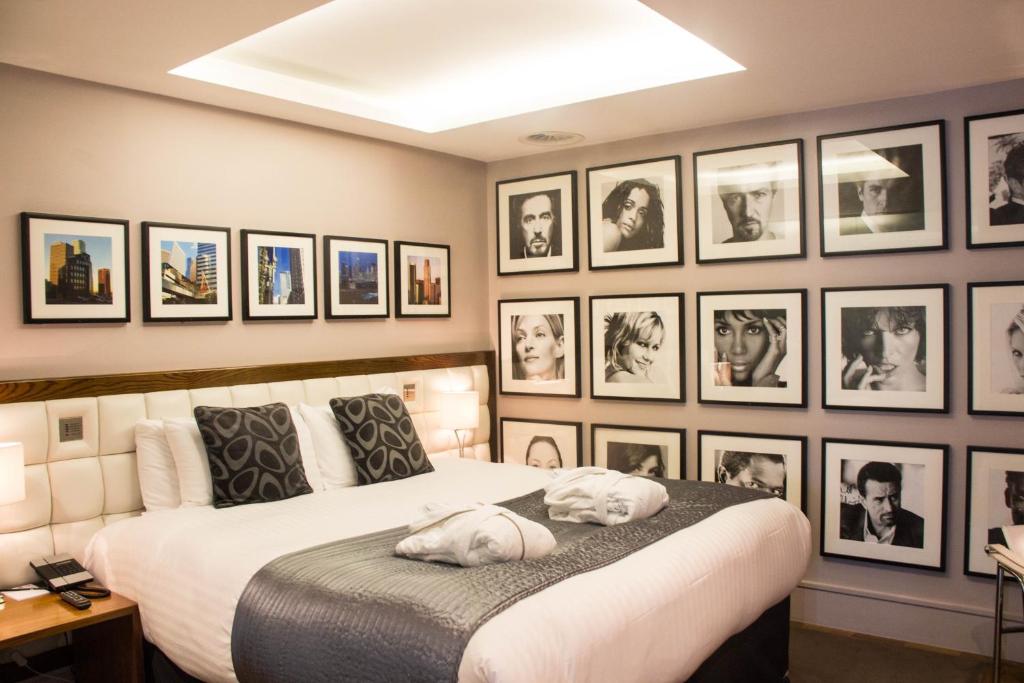 una camera da letto con un letto con un mucchio di foto appese al muro di Le Monde Hotel a Edimburgo