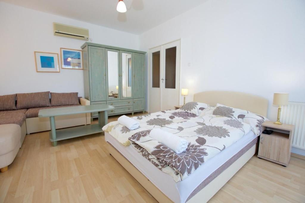 ハイドゥソボスローにあるZoli Apartmanok-Balcony Kölcsey 32のベッドルーム(大型ベッド1台、ソファ付)