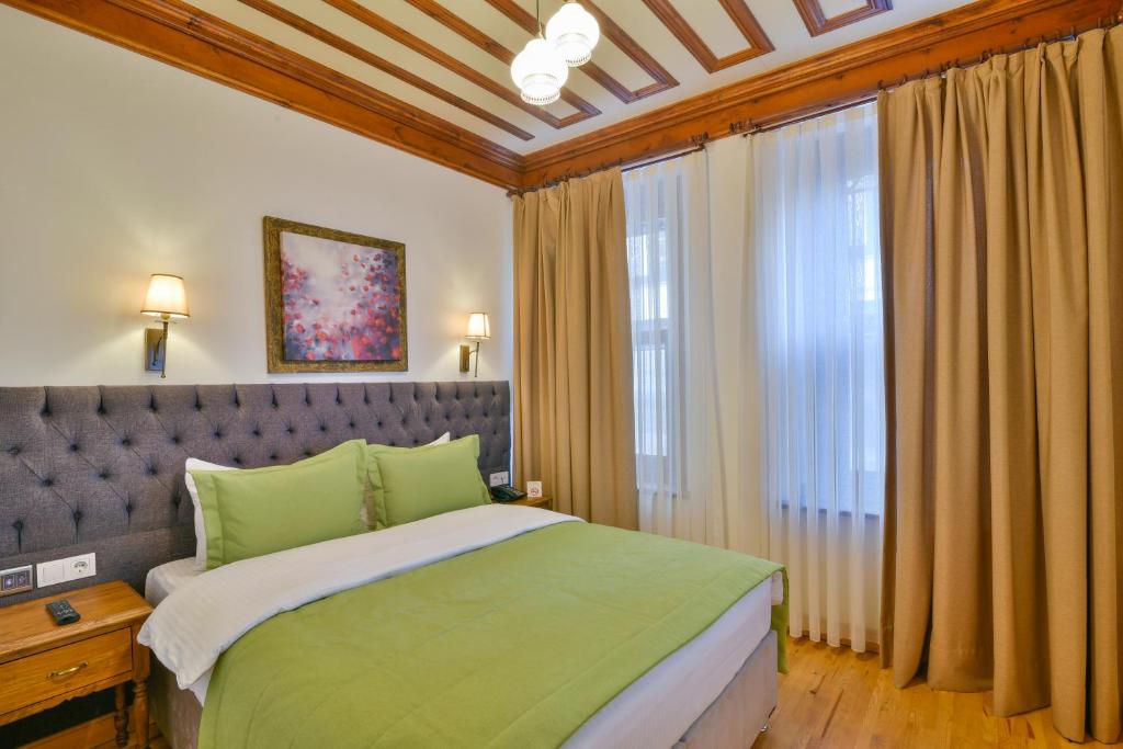 a bedroom with a green bed and a window at Istanbul Life Hotel in Istanbul