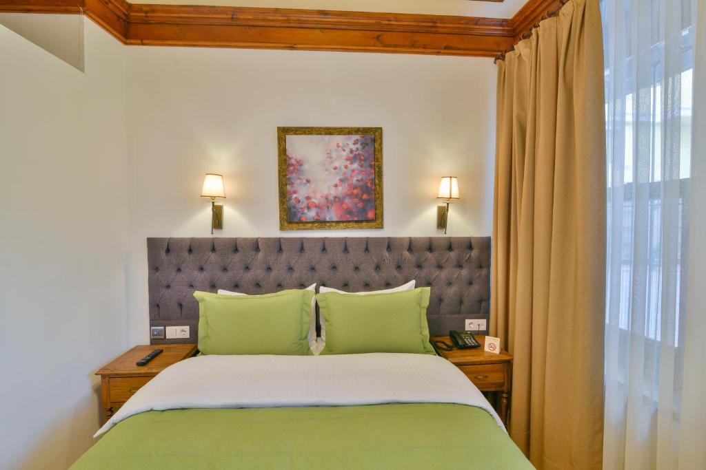 a bedroom with a large bed with green pillows at Istanbul Life Hotel in Istanbul