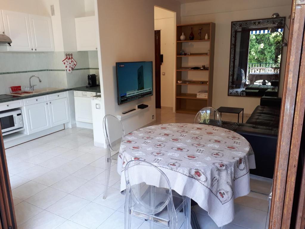 une cuisine et une salle à manger avec une table et une télévision dans l'établissement Appart bas Fabron, à Nice