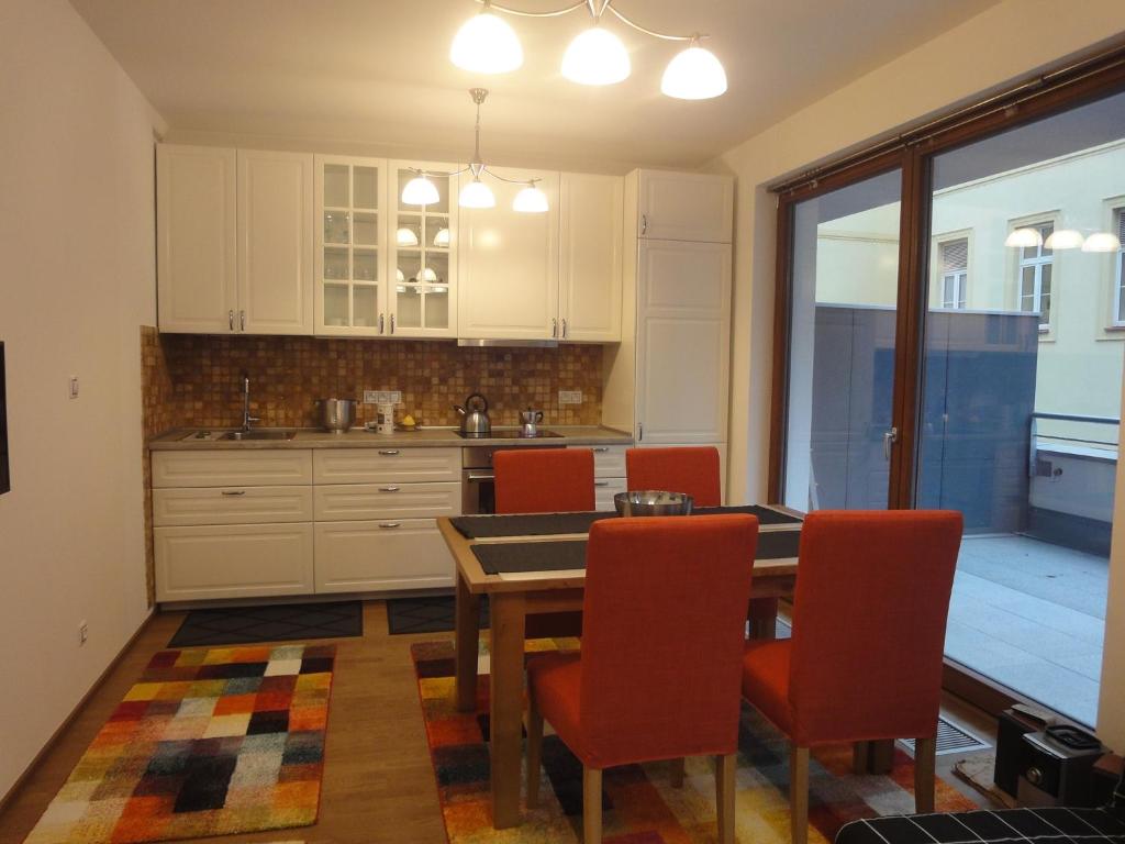 een keuken met een eettafel en rode stoelen bij Apartman Mozartova in Praag