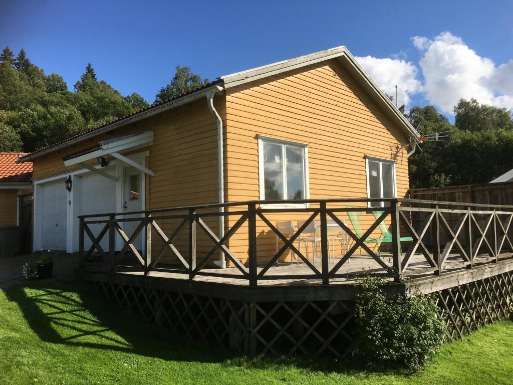 a house with a large wooden deck in the yard at Lilla Skottek in Ulricehamn