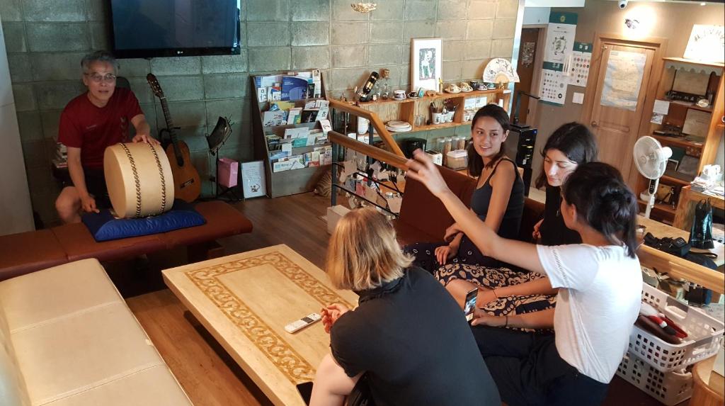 a group of people sitting in a room with a instrument at Nearest Guesthouse in Jeonju