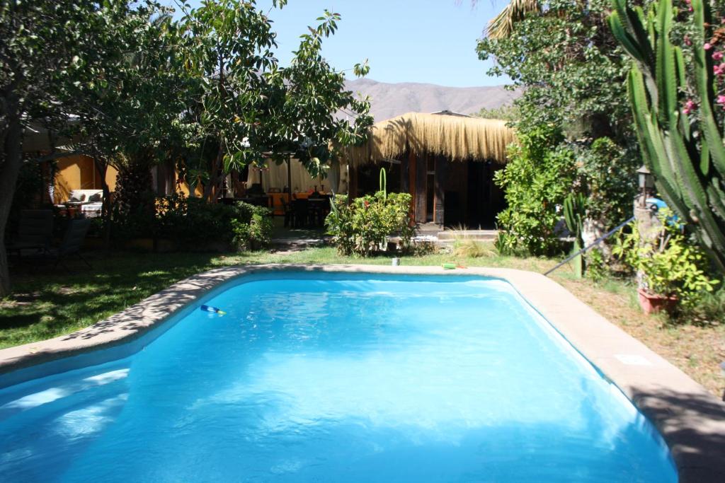 a large blue swimming pool in front of a house at Tikay Suite Hotel in Copiapó