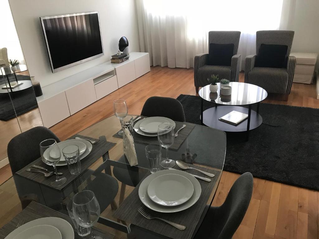 uma sala de estar com uma mesa e cadeiras e uma televisão em Luxury Apartment T2 - Saldanha em Lisboa