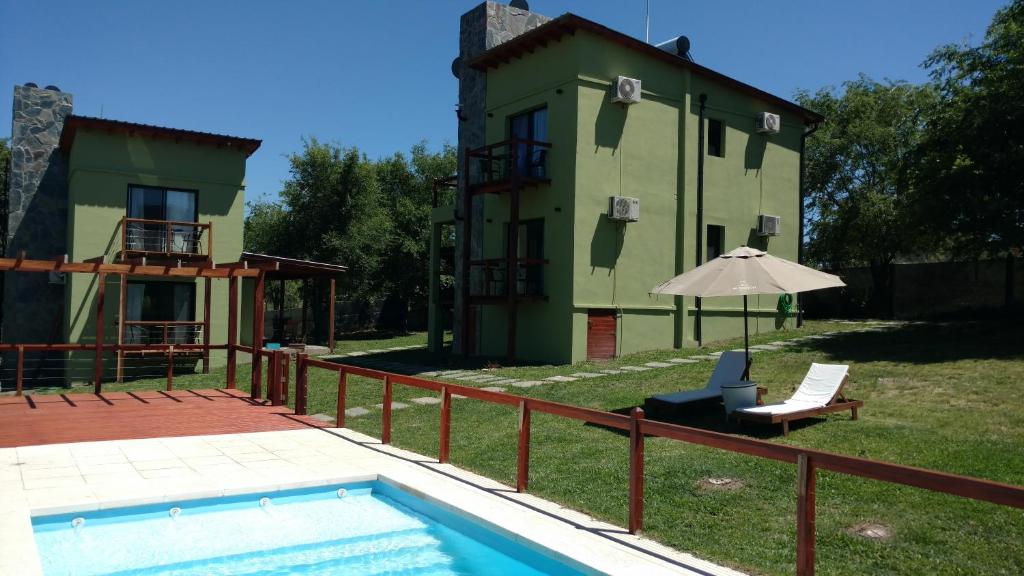 a villa with a swimming pool and a house at El Breton in Potrero de Garay
