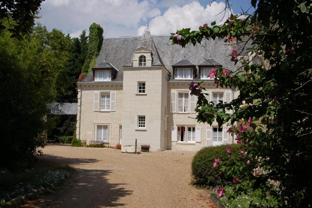 a large stone house with a driveway at Logis Manoir De La Giraudière in Beaumont-en-Véron