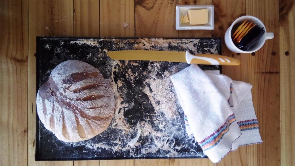 a cutting board with a knife and a loaf of bread at Treehouse Patagonia in Puerto Natales