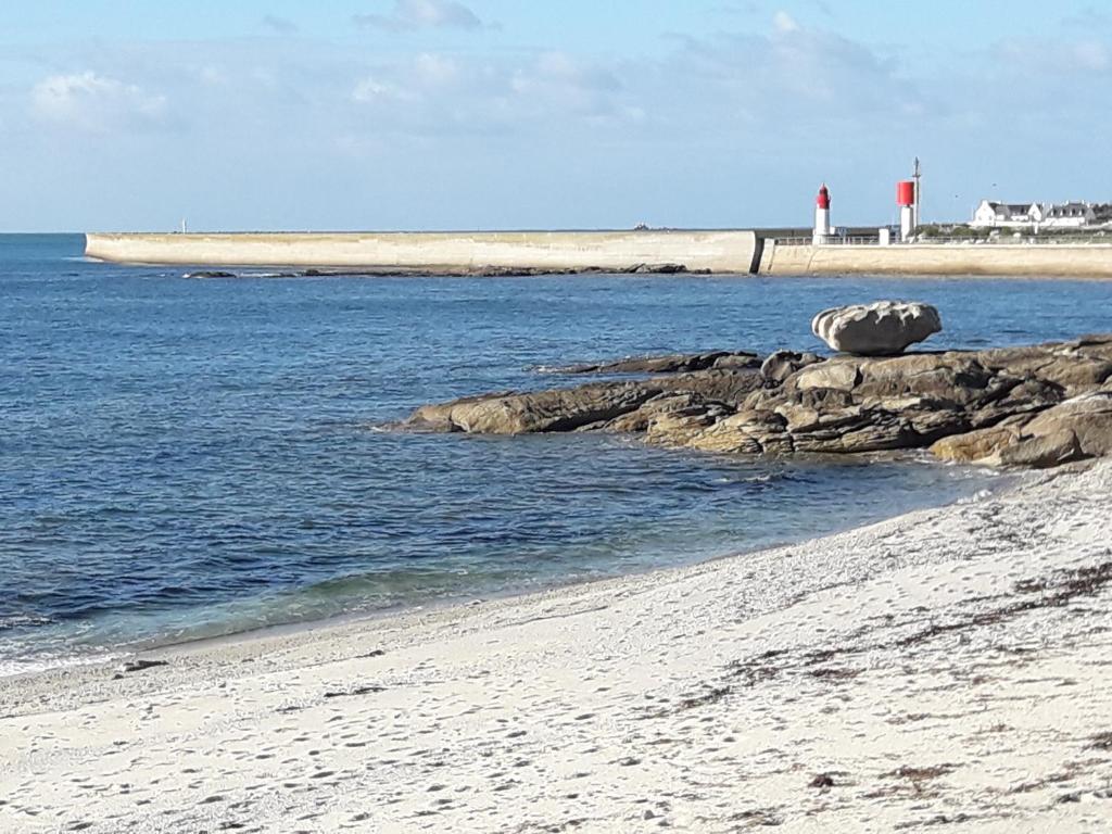 une plage avec une masse d'eau et un phare dans l'établissement appartement proche de la mer, au Guilvinec
