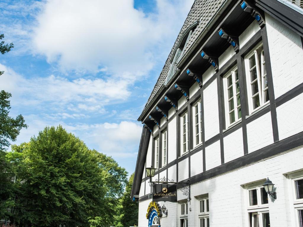 a building with a black and white building at Hotel Waldesruh Am See in Aumühle