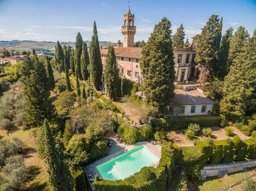 an aerial view of a mansion with a swimming pool and trees at Montegufoni by PosarelliVillas in Montagnana Val di Pesa