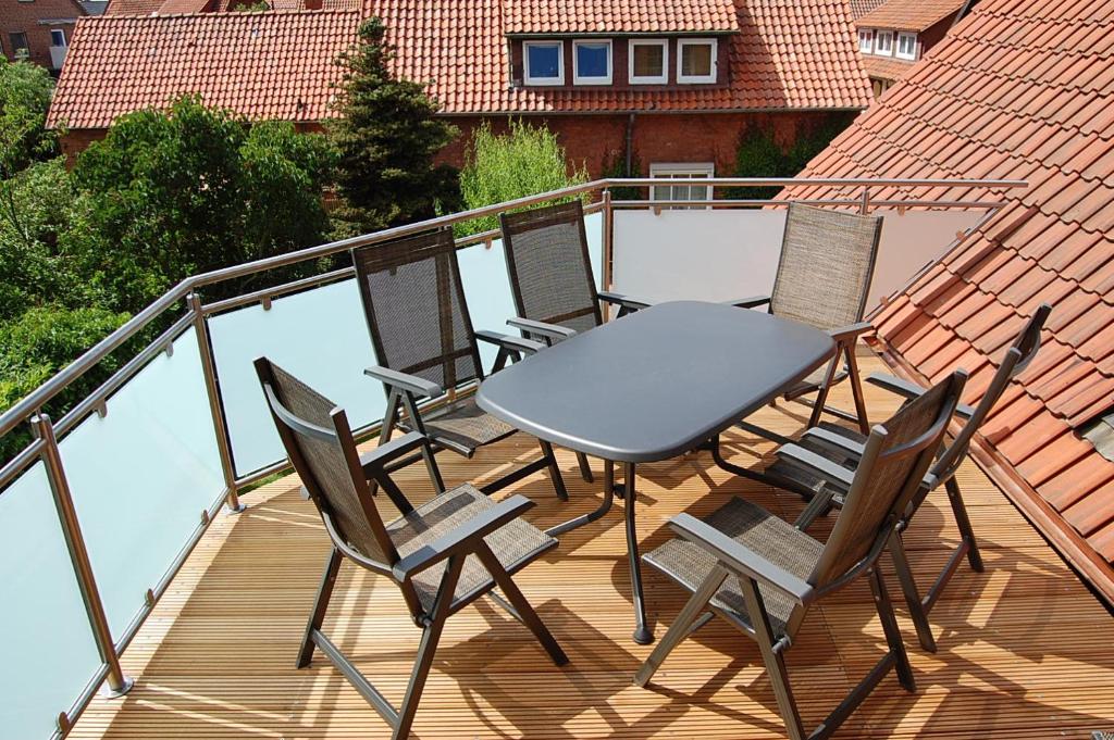 une table et des chaises assises sur un balcon dans l'établissement Ferienwohnung Stollenwerk am Steinhuder Meer - Wunstorf OT Steinhude An der Schanze 7, à Steinhude