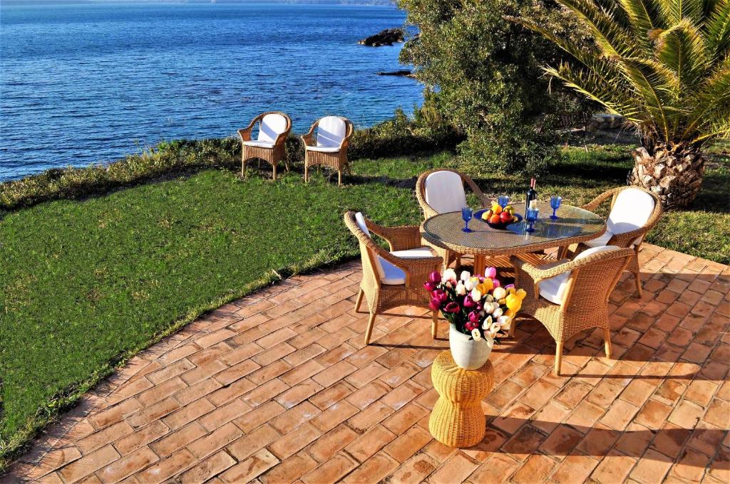a patio with a table and chairs next to the water at Villa Tiziana in Casa Morcone