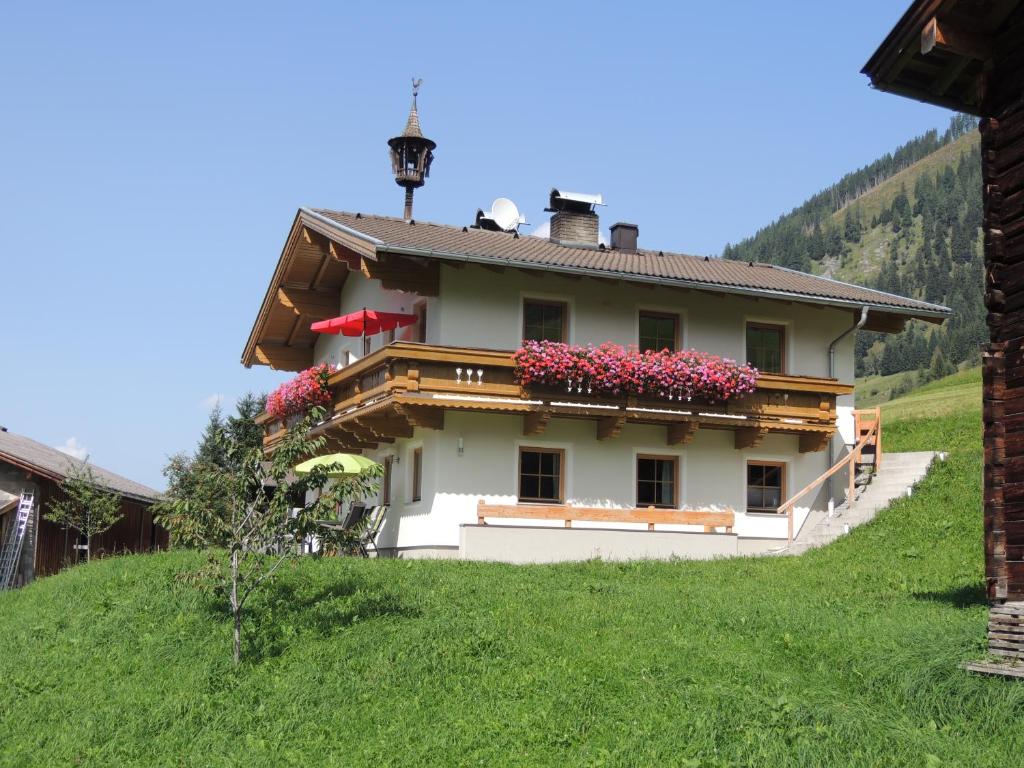 Una casa en una colina con flores. en Ferienhaus Tauernblick, en Rauris