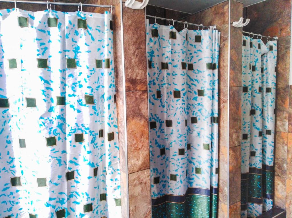 a bathroom with a blue and white shower curtain at Hostal CQ Chapinero in Bogotá
