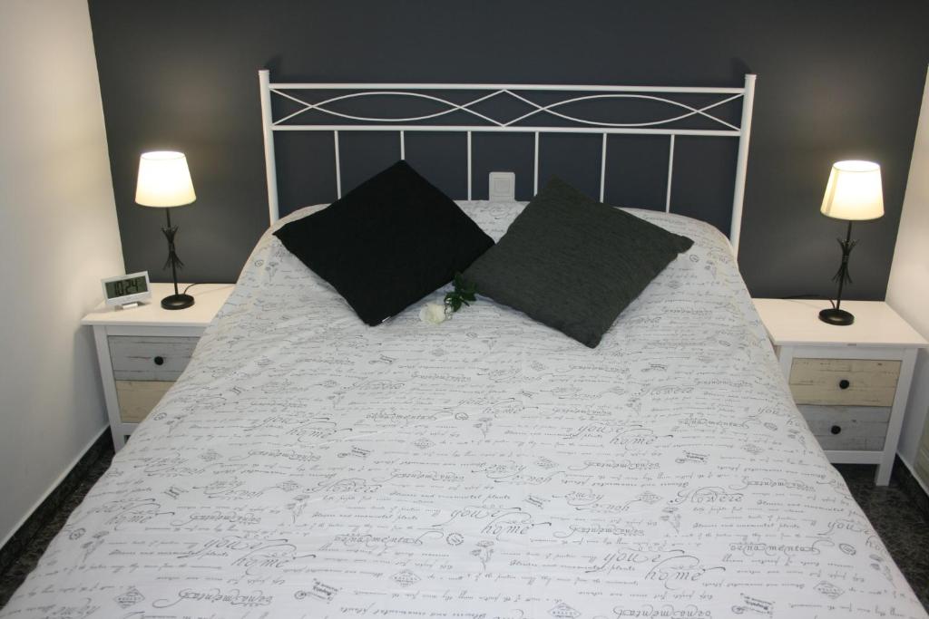 1 dormitorio con cama blanca y almohadas negras en Ésera Dos Catedrales en Villanova