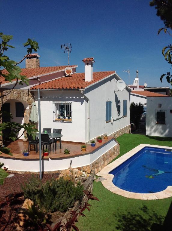 a villa with a swimming pool in front of a house at Delightful Villa close to the beach in L'Escala
