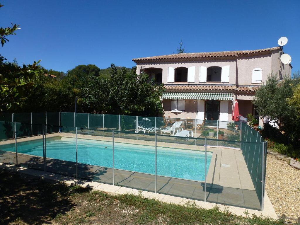 a house with a swimming pool and a fence at B&B Sita in Saint-Cyr-sur-Mer