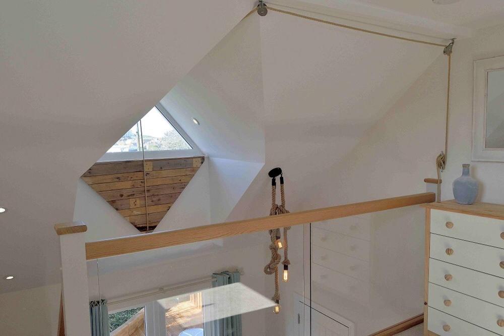 a staircase in a house with a window at Little Fernleigh in Perranporth