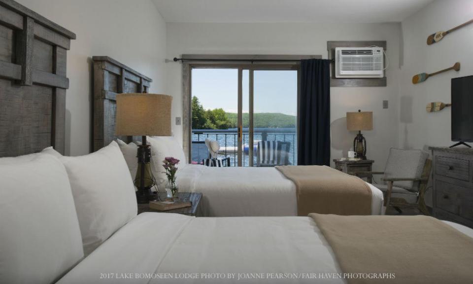 een hotelkamer met 2 bedden en een balkon bij Lake Bomoseen Lodge in Bomoseen