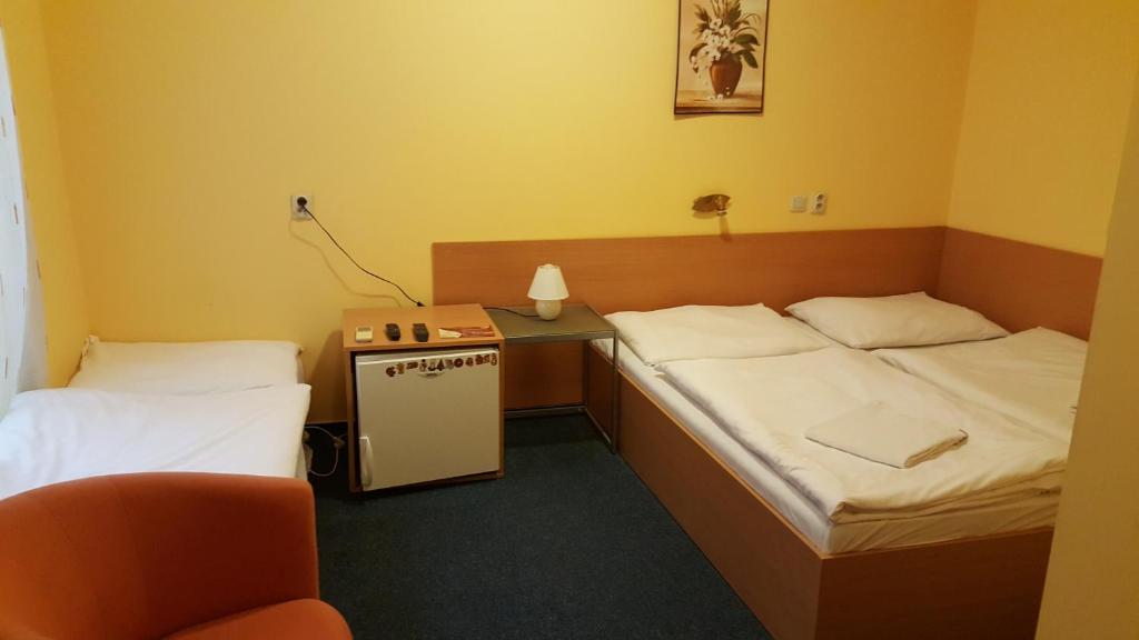 A bed or beds in a room at Lehár panzió