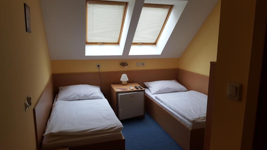A bed or beds in a room at Lehár panzió